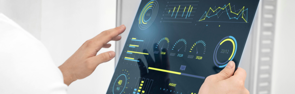 Pessoa interagindo com um painel de dados digital com gráficos e indicadores